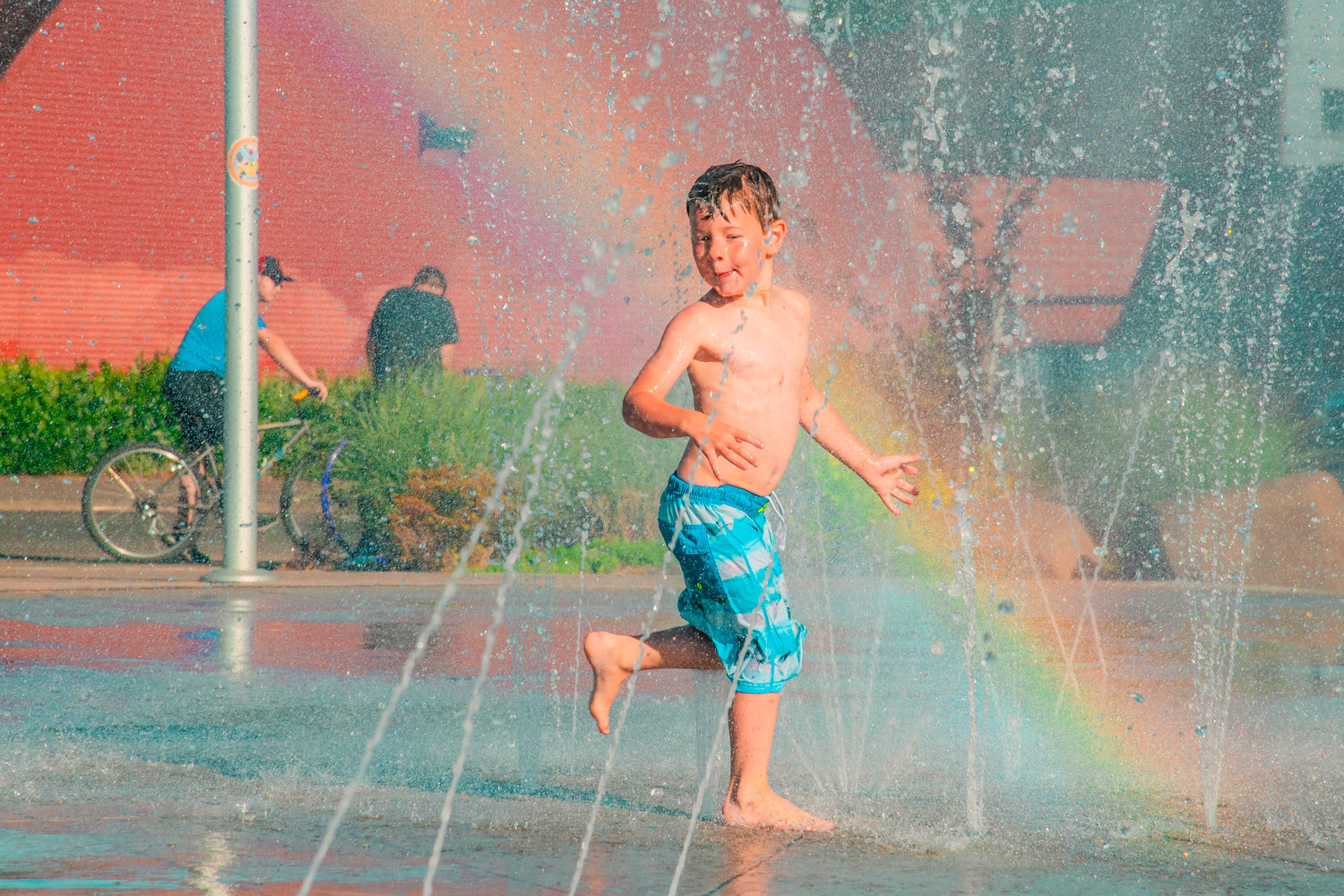 Tyrel Newkirk, 5, runs through streams of water to cool off at the Centralia splash park on Tuesday.