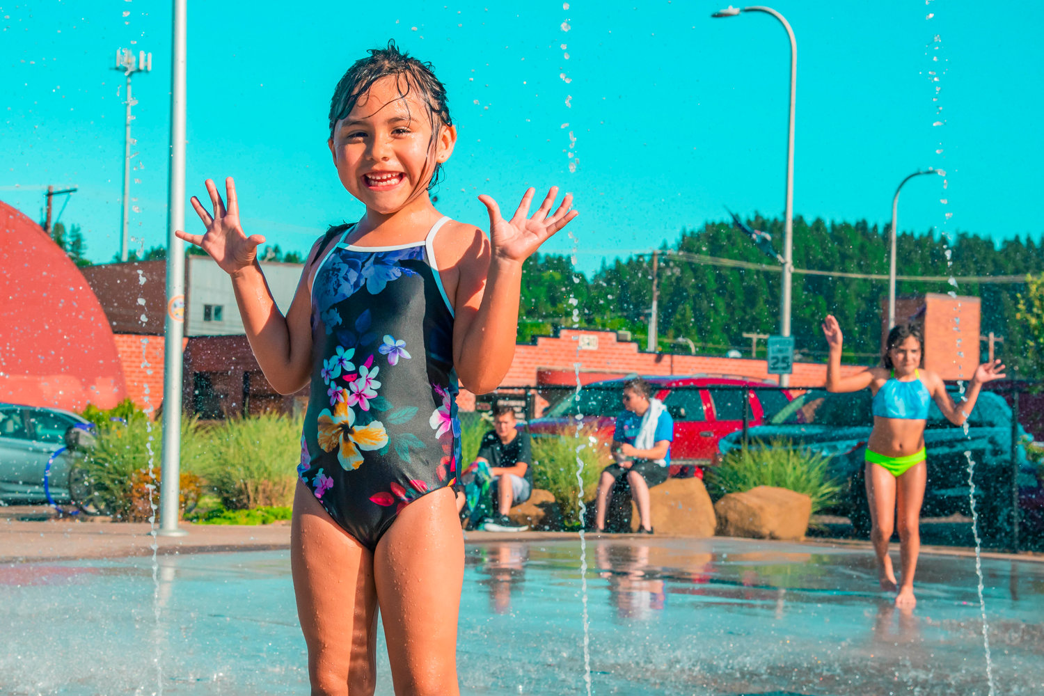 Luna Andablo smiles while playing in the Centralia splash park on Tuesday.