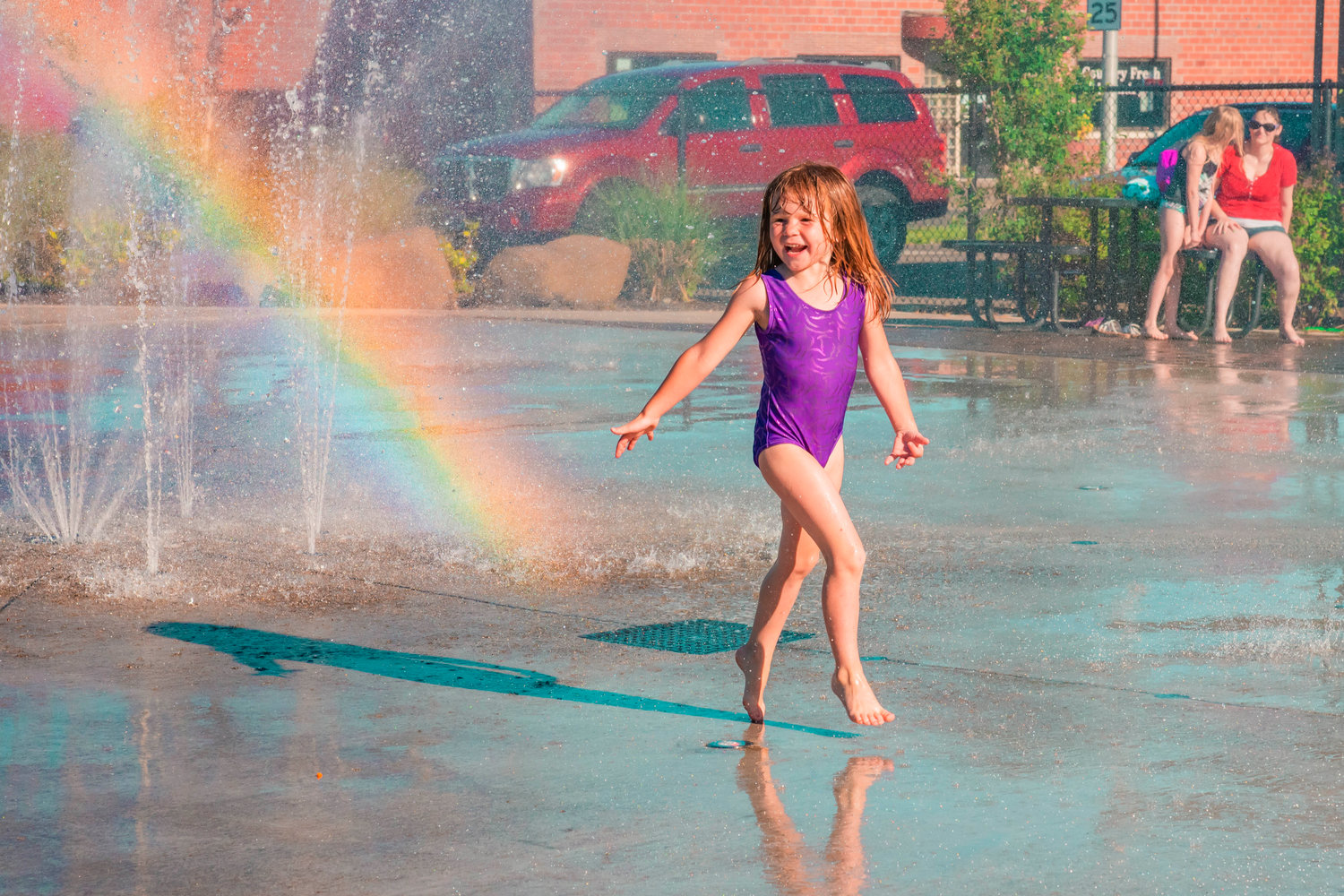 Emma Newkirk, 4, smiles and plays in the newly reopened splash pad, Tuesday afternoon in Centralia.