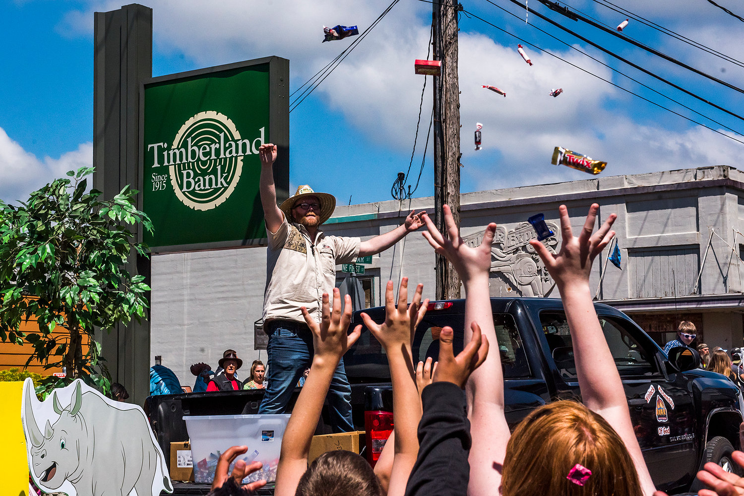 Kids reach to the sky as candy falls after being thrown from the Winlock Assembly float in 2019.