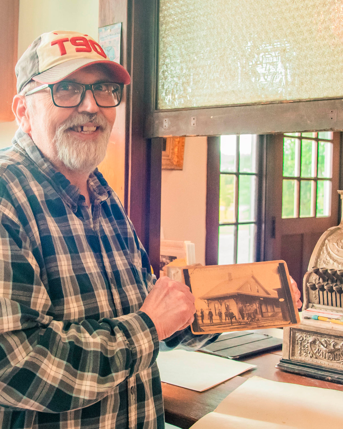 Tenino City Historian Richard Edwards smiles while holding up one of the earliest known photos of Tenino on Tuesday.