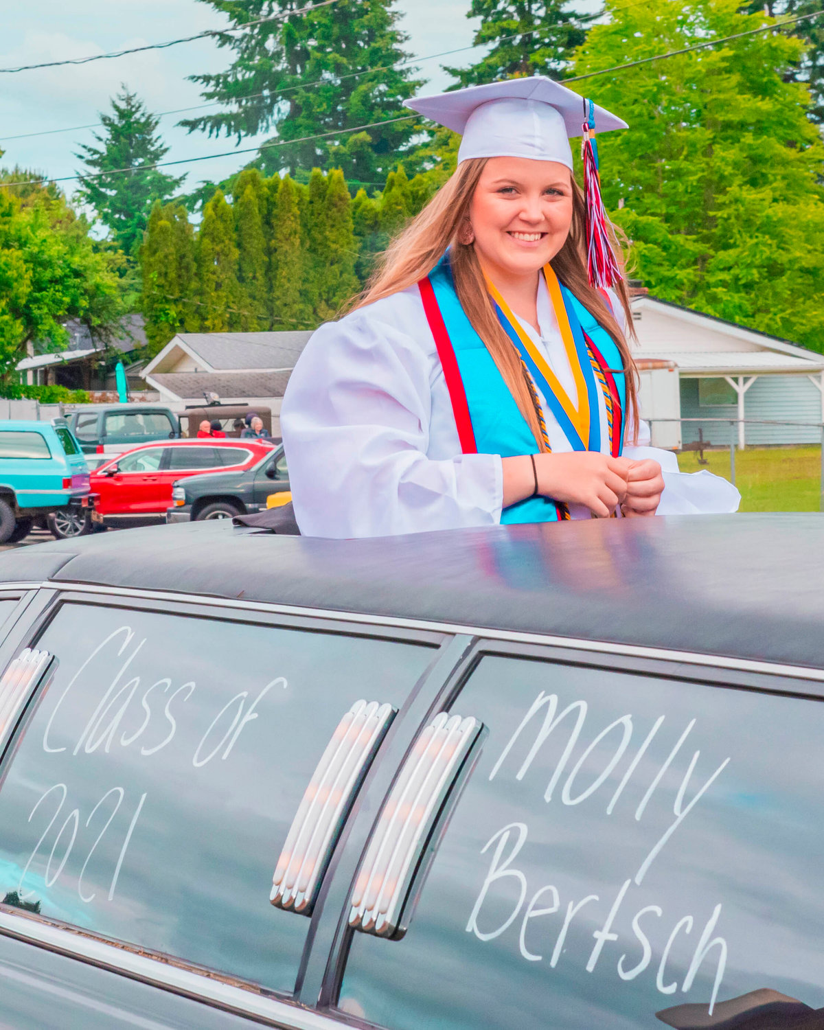 Molly Bertsch smiles out the sunroof of a limo during a graduation parade on Saturday in Tenino.