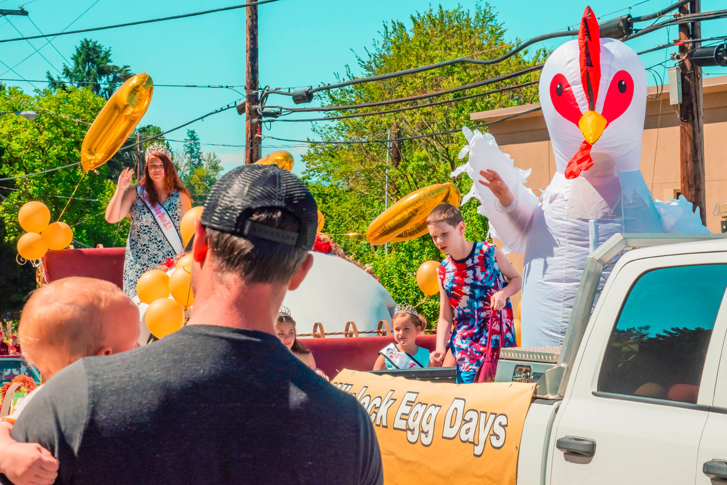 Kids wave from a float during the Winlock Egg Days parade on Saturday.