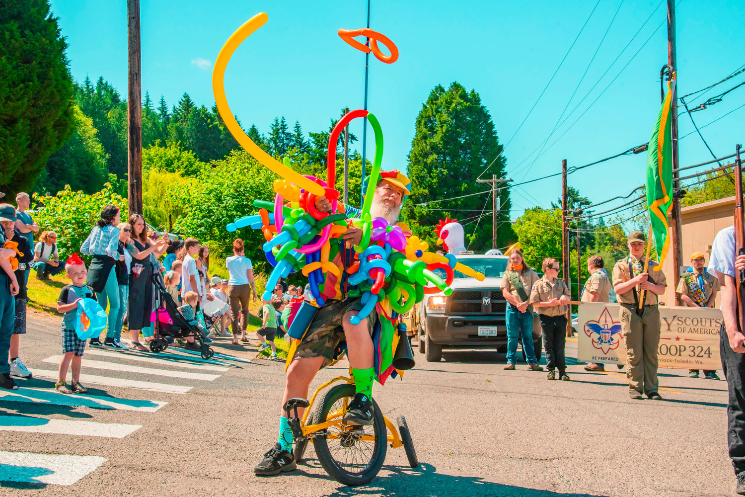 Ken Trombley, a baloon artist known as the BaLunatic, rides a tricycle while filling baloons with air during the Winlock Egg Days parade on Saturday.