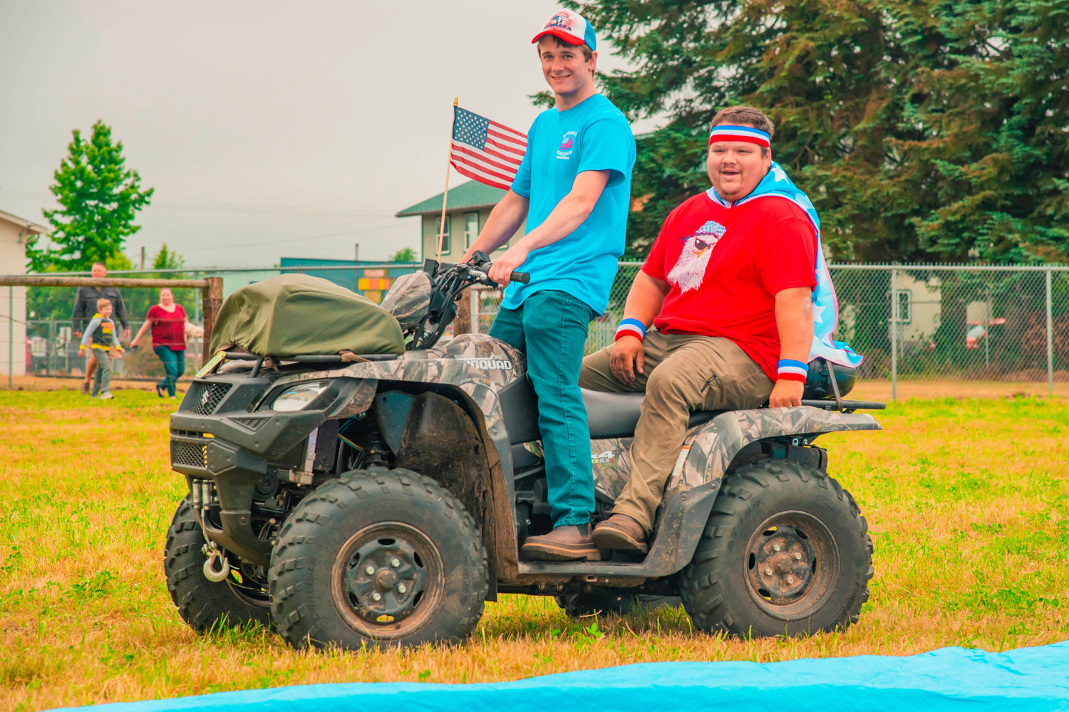 Volunteers drive through Klickitat Prairie Park on a quad while sporting red, white and blue attire Saturday in Mossyrock.