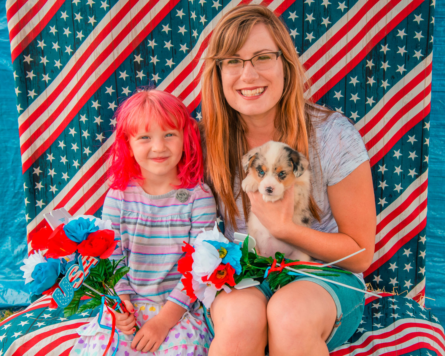 Florisa Bacon and Caroline Bowes pose for a photo with Piper, a Corgi, at Rosie’s photo booth during the Mossyrock Freedom Festival on Saturday in Klickitat Prairie Park.