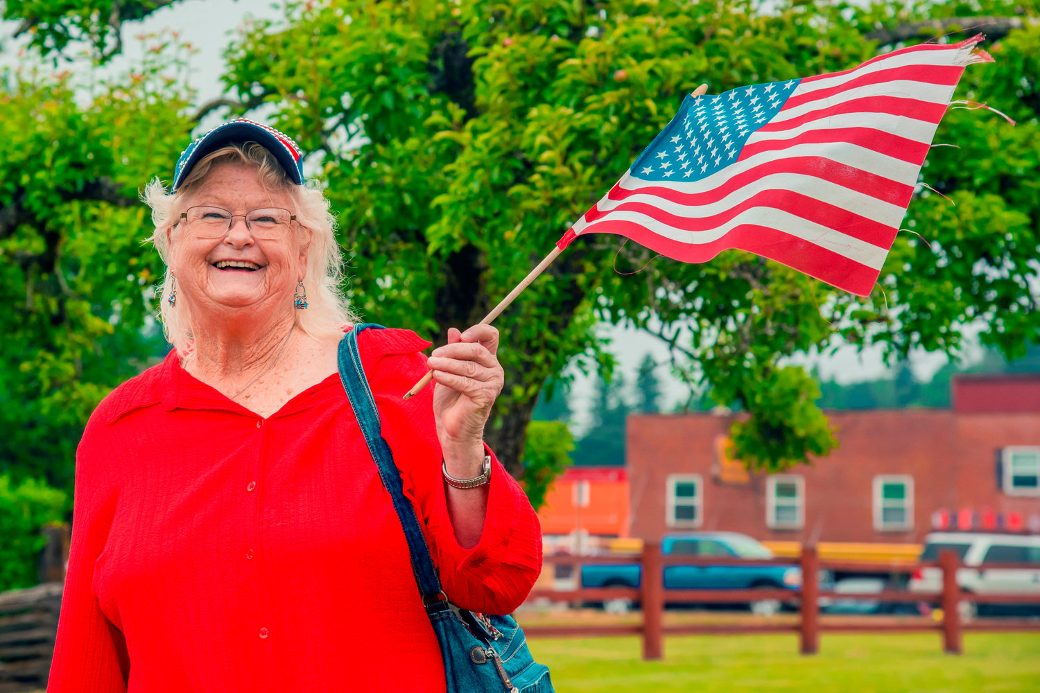 Alice Shinn, of Silver Creek, smiles and waves an American Flag during the Mossyrock Freedom Festival on Saturday.