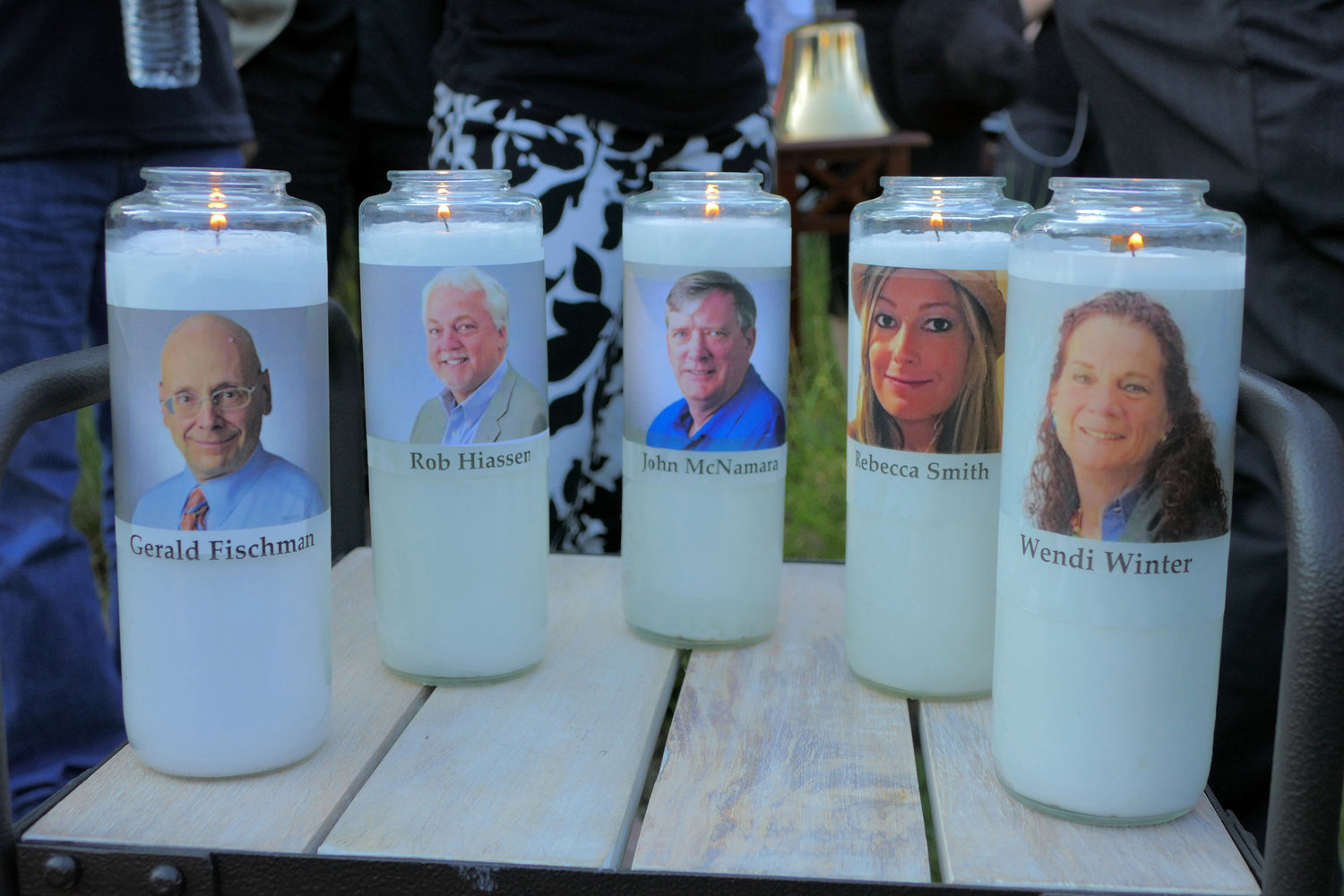 Candles honoring Gerald Fischman, Rob Hiassen, John McNamara, Rebecca Smith, and Wendi Winters flicker as the sun sets during a candlelight vigil on June 29, 2018, at Annapolis Mall for the five Capital Gazette employees slain during a shooting spree in their newsroom.