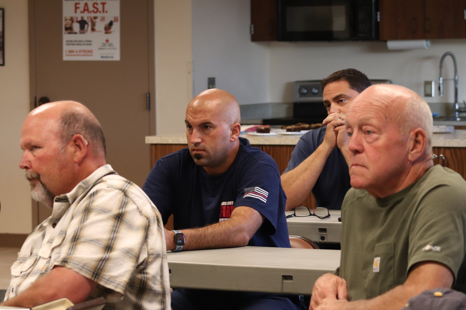 Firefighters sit amongst Adna community members at a Lewis County Fire District 6 board of commissioners meeting on July 27.
