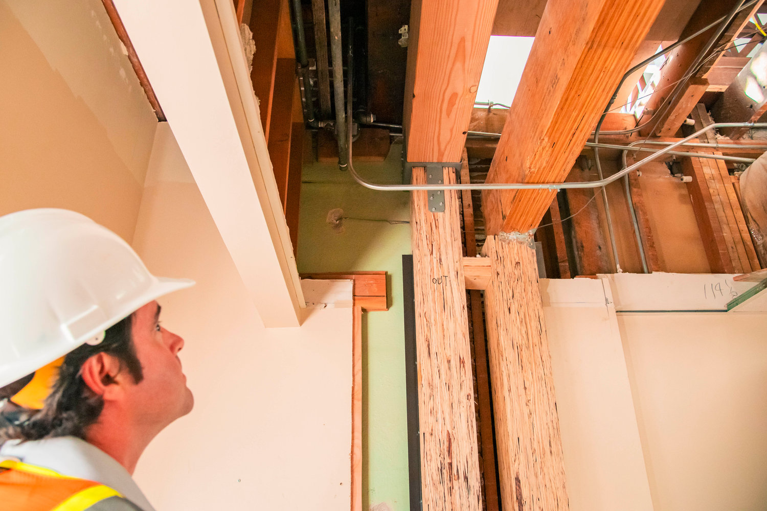 FILE PHOTO — Architect Sam Schafer of Seattle-based Integrus Architecture, talks about newly installed wooden beams used to reinforce the walls holding up the roof of Edison Elementary during seismic upgrade construction last summer.