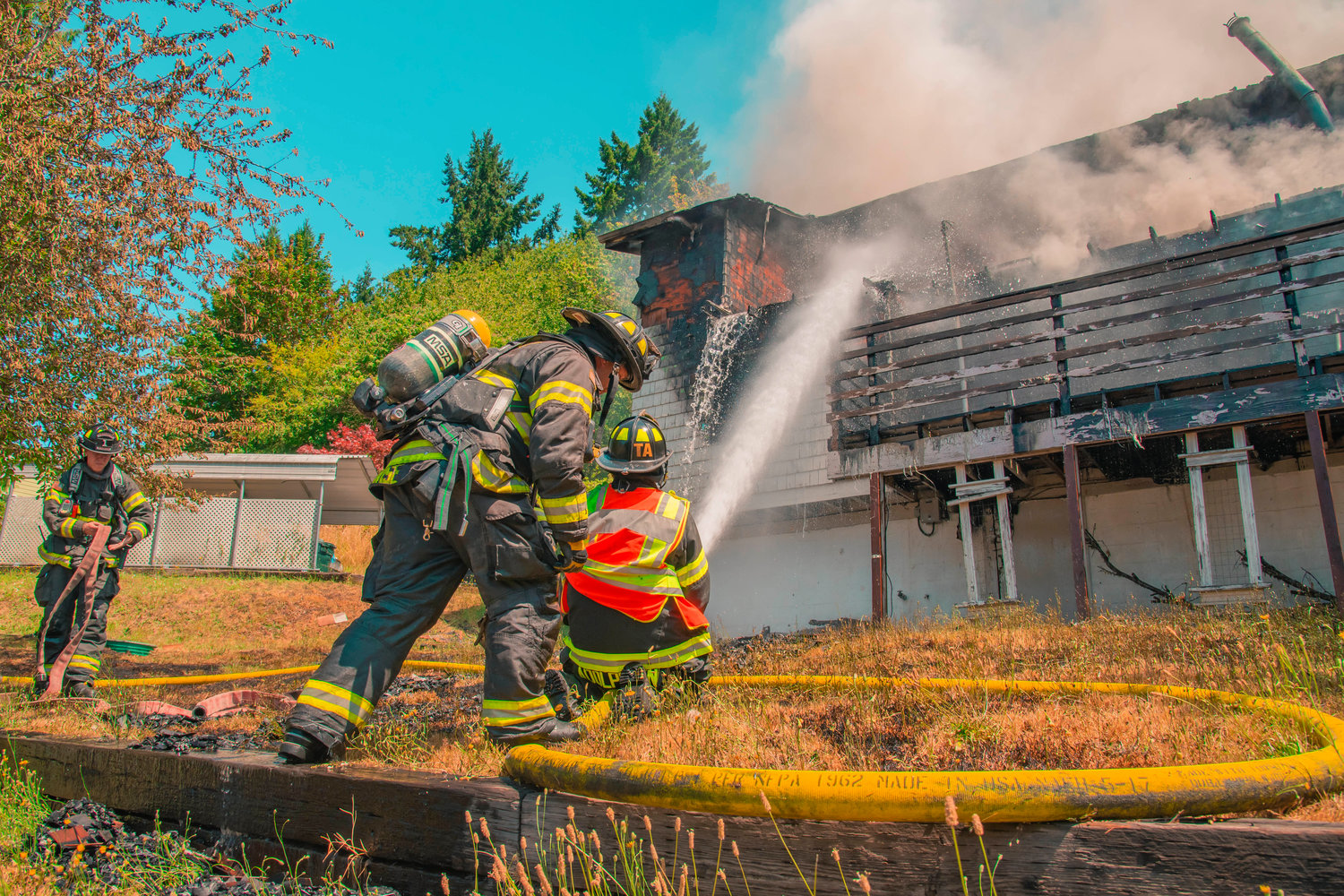 Riverside Fire Authority firefighters use hoses to put out flames at a residential structure on East Third Street in Centralia on Thursday.