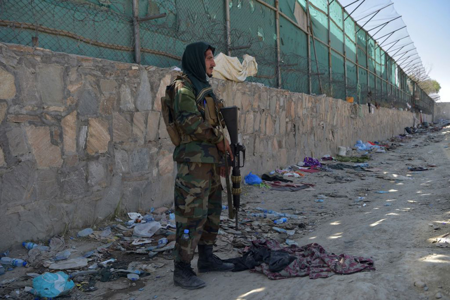 A Taliban fighter stands guard at the site of the August 26 twin suicide bombs, which killed scores of people including 13 US troops, at Kabul airport on August 27, 2021. (Wakil Kohsar/AFP via Getty Images/TNS)
