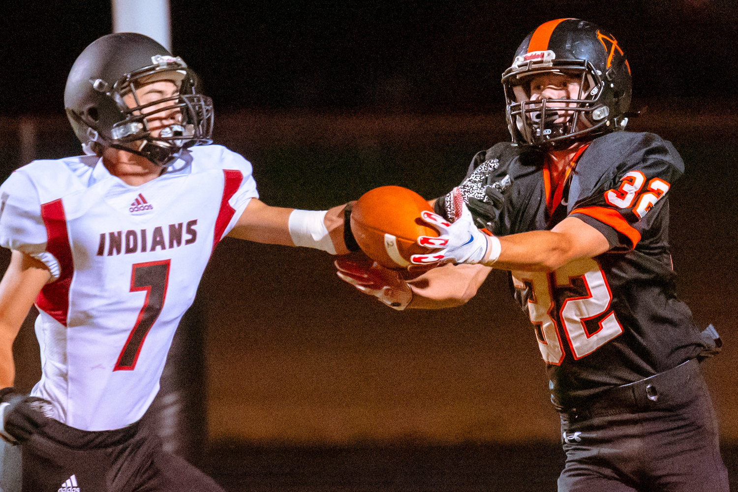 A pass intended for Rainier’s Jake Meldrum (32) is broken up by Toledo’s Aiden Umbriaco (7) under Friday night lights.