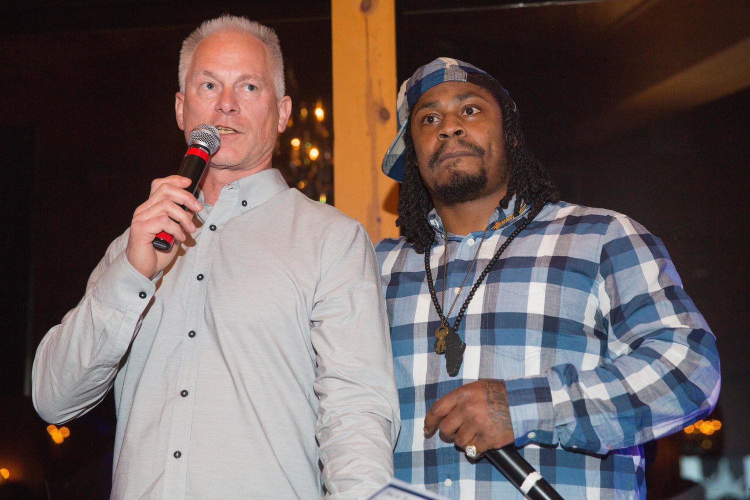 Kenny Mayne, left and Marshawn Lynch speak during a 2014 charity event at The Edgewater Hotel in Seattle. (Mat Hayward/Getty Images for 1st Family Foundation/TNS)