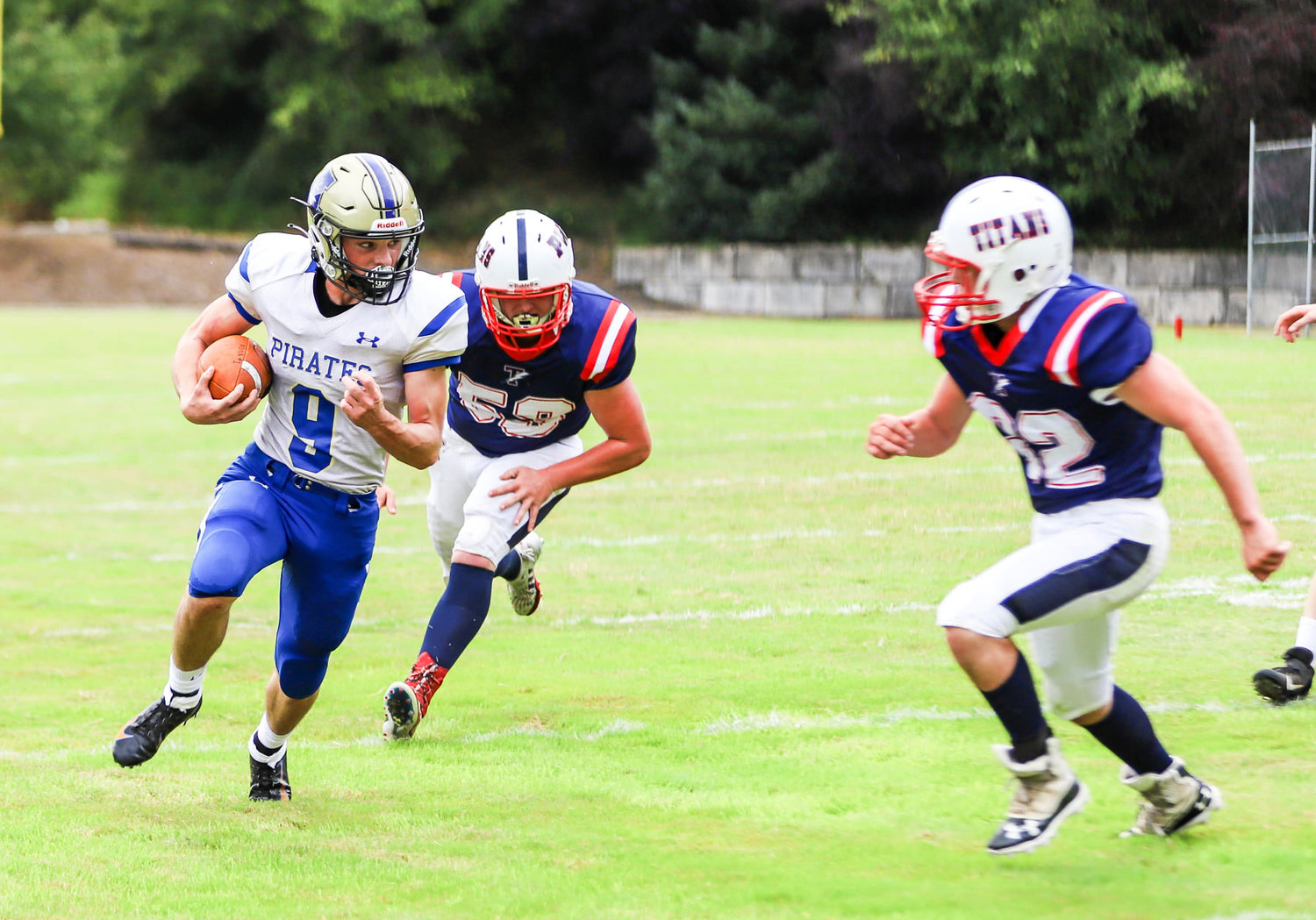 Adna running back Tristan Ridley (9) runs around end against two PWV defenders on Saturday.