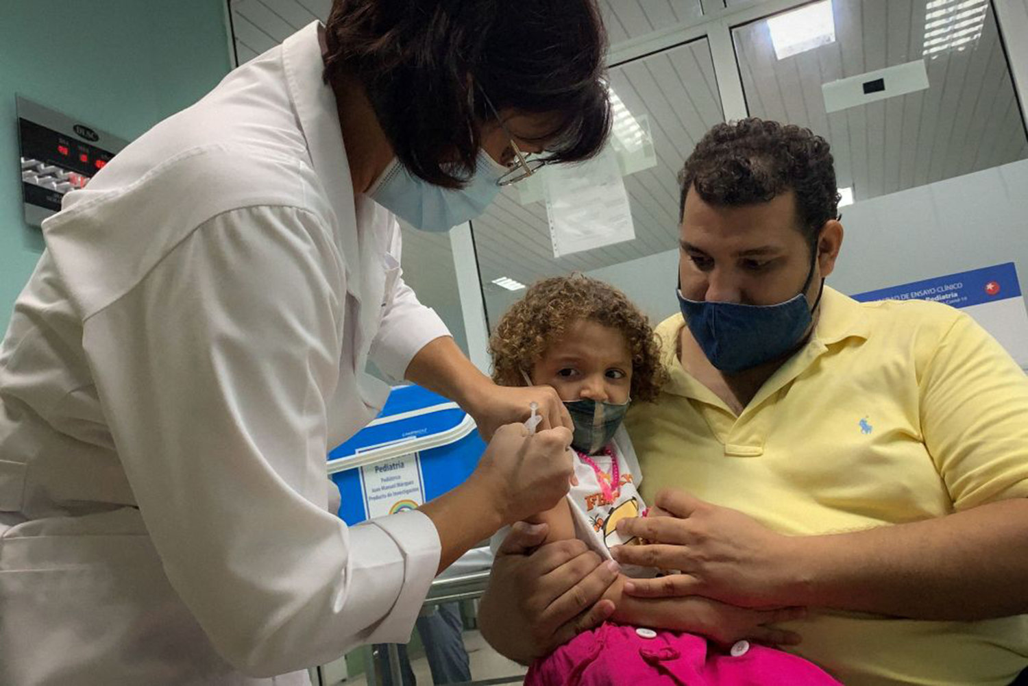 Pedro Montano holds his daughter Roxana Montano, 3, while she is being vaccinated against COVID-19 with Cuban vaccine Soberana Plus, on August 24, 2021 at Juan Manuel Marquez hospital in Havana, as part of the vaccine study in children and adolescents. (Adalberto Roque/AFP via Getty Images/TNS)