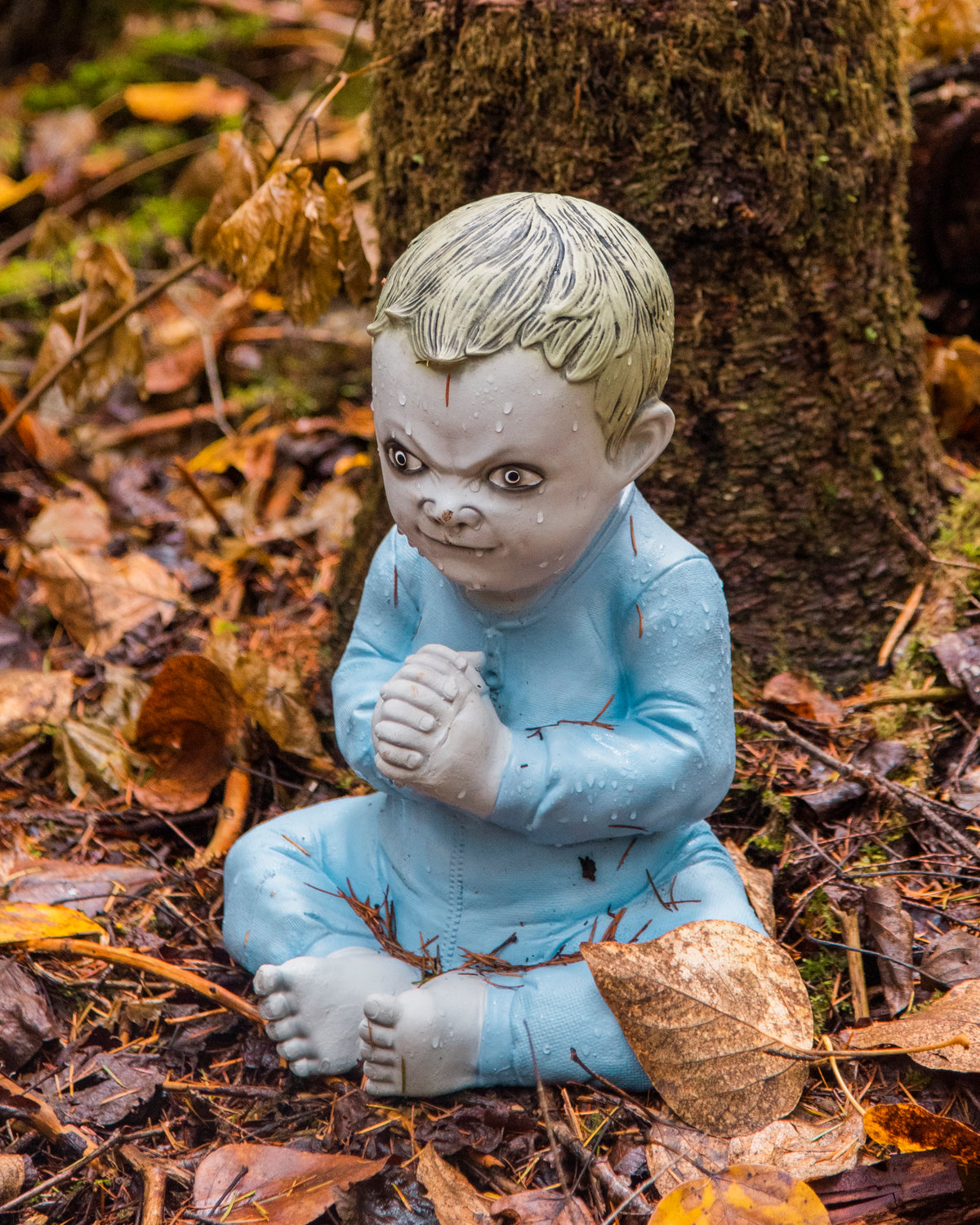A spooky figure resembling a child sits next to a stump in the haunted forest in The Huntting’s Farm in Cinebar Wednesday afternoon.