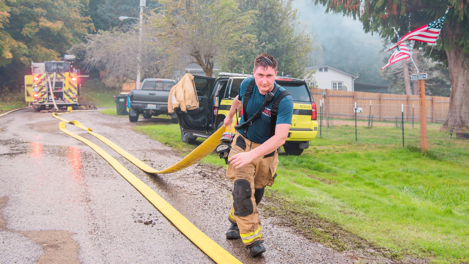 Wyatt “Nutty” Hill, of Lewis County Fire District 6, works to move hose lines following a fire in Pe Ell Thursday afternoon.
