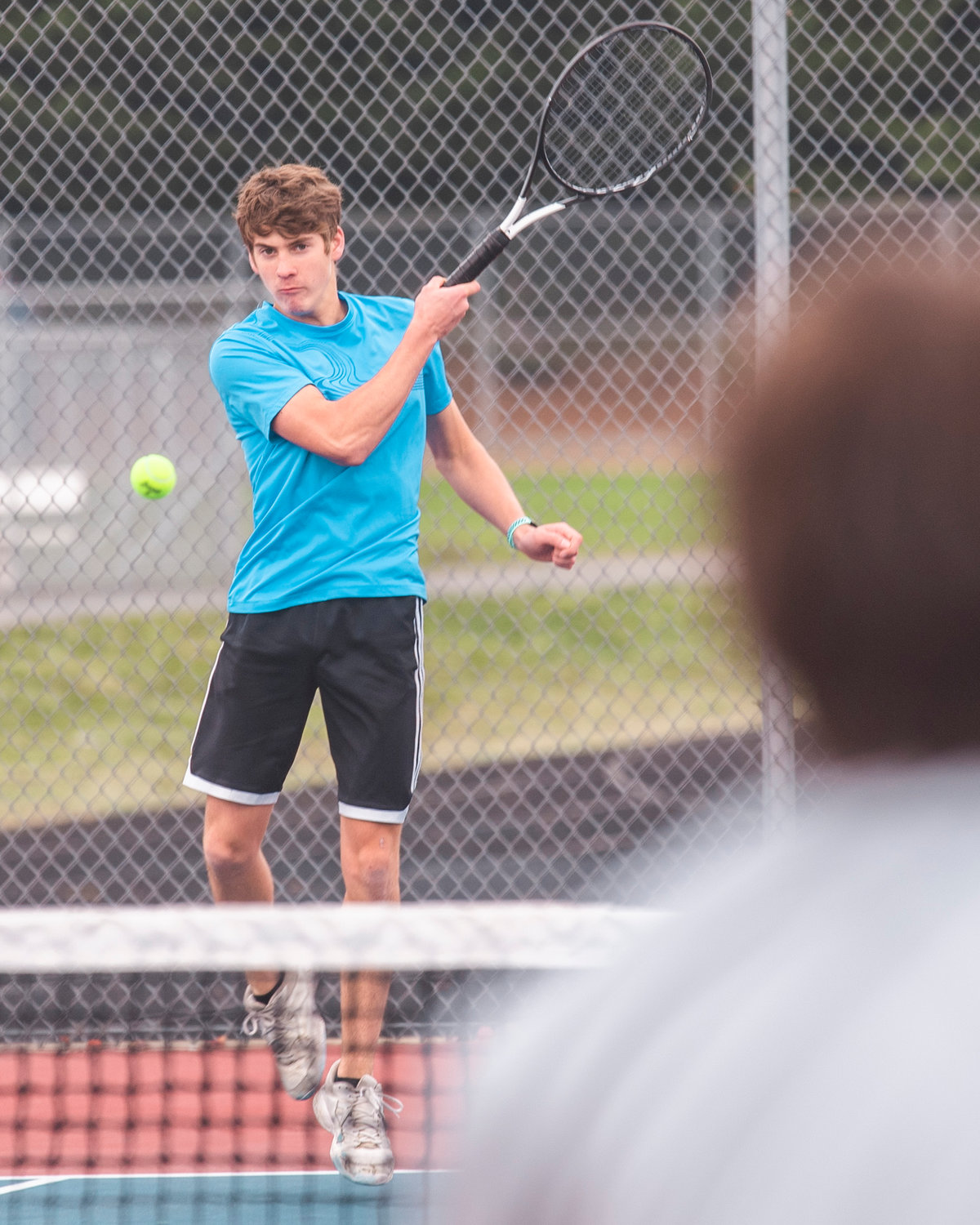 W.F. West’s Aaron Boggess watches his shot during a doubles match at Black Hills High School Tuesday afternoon.