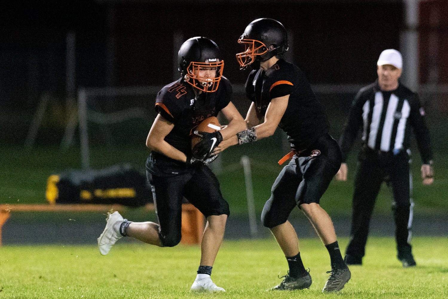 Napavine quarterback Ashton Demarest hands the ball off to Peyton League on a fly sweep against Forks Oct. 22.