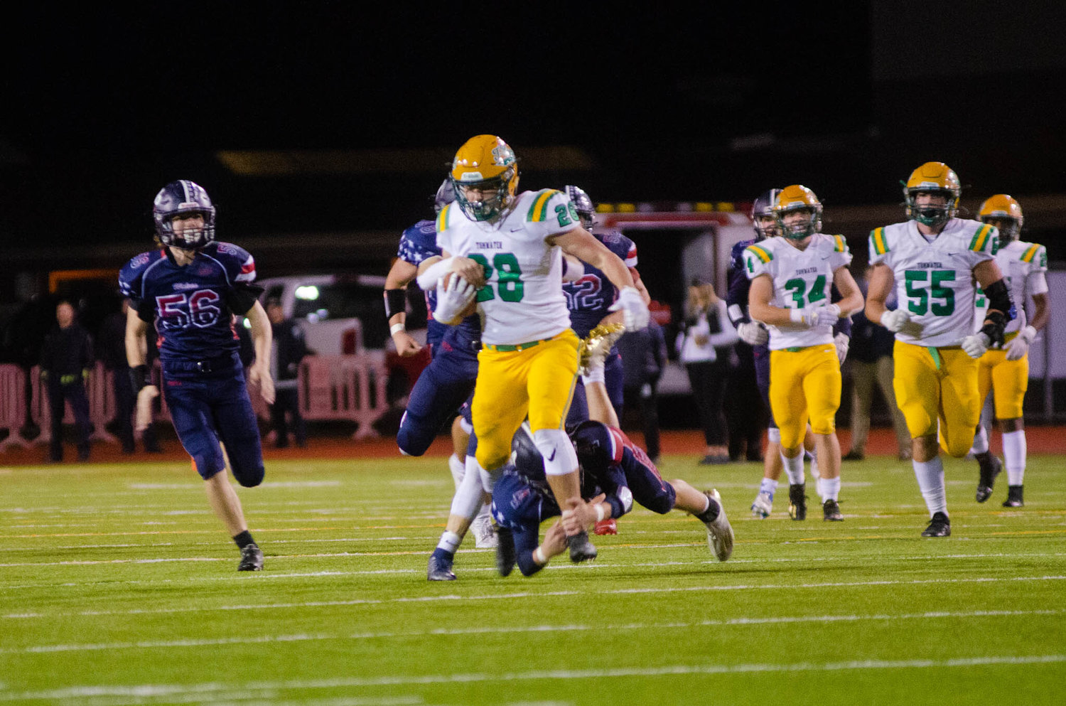 Tumwater’s Ryan Orr rushes the ball forward as Black Hills lineman attempt to stop him. The Thunderbirds shellacked the Wolves to win the Pioneer Bowl 50-7 Friday night.