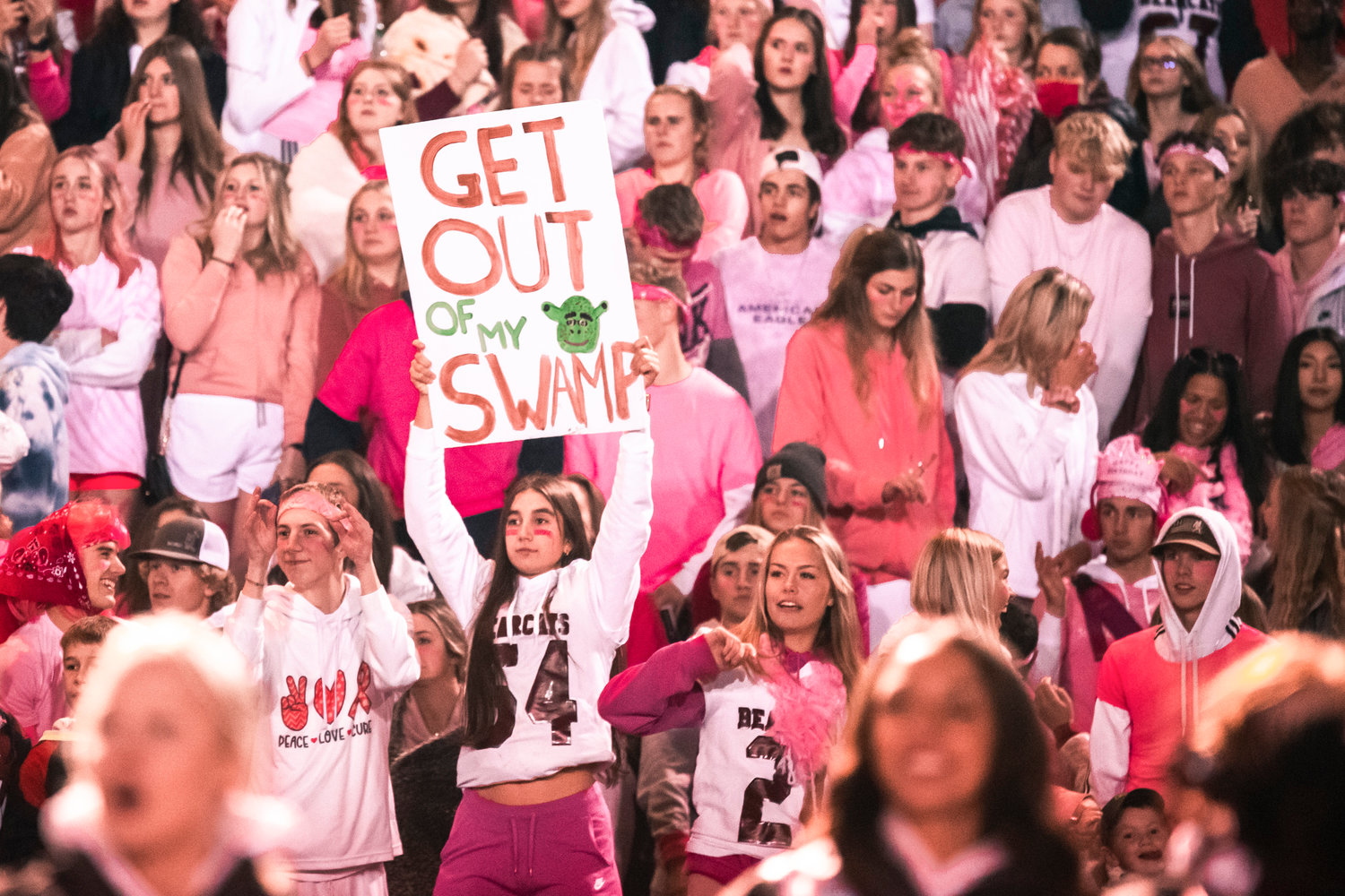 Bearcat fans hold signs and cheer as they watch W.F. West and Centralia football players battle it out on the field Friday night during the Swamp Cup rivalry matchup.