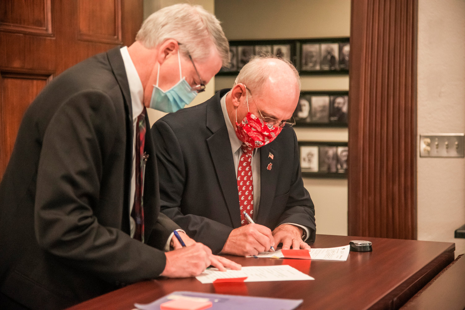 Judge James Lawler signs papers alongside Commissioner Lee Grose following a swearing in ceremony Wednesday morning at the Lewis County Courthouse in Chehalis.