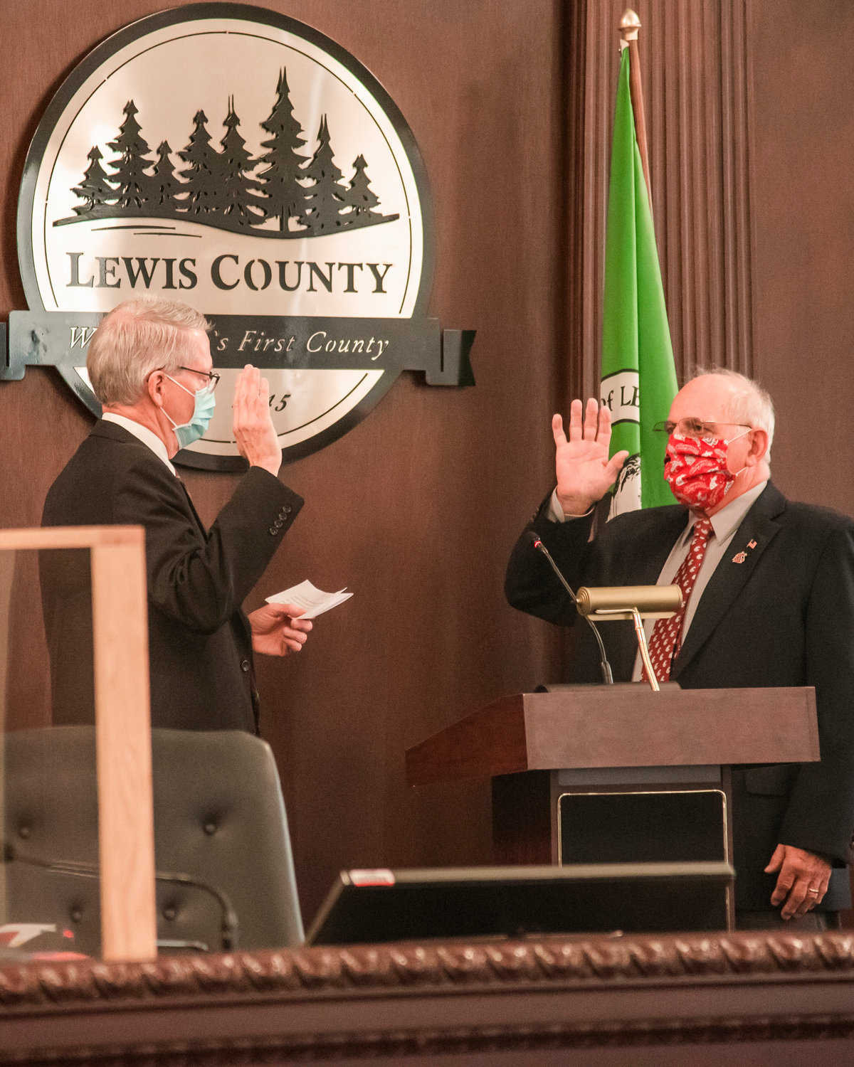 Lee Grose, right, and Judge James Lawler raise their right hands during a swearing in ceremony Wednesday morning in the commission chambers.