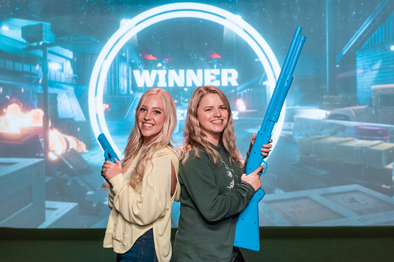 Visitors smile pose with their weapons after conquering virtual aliens at Par 4 Sports in Centralia.