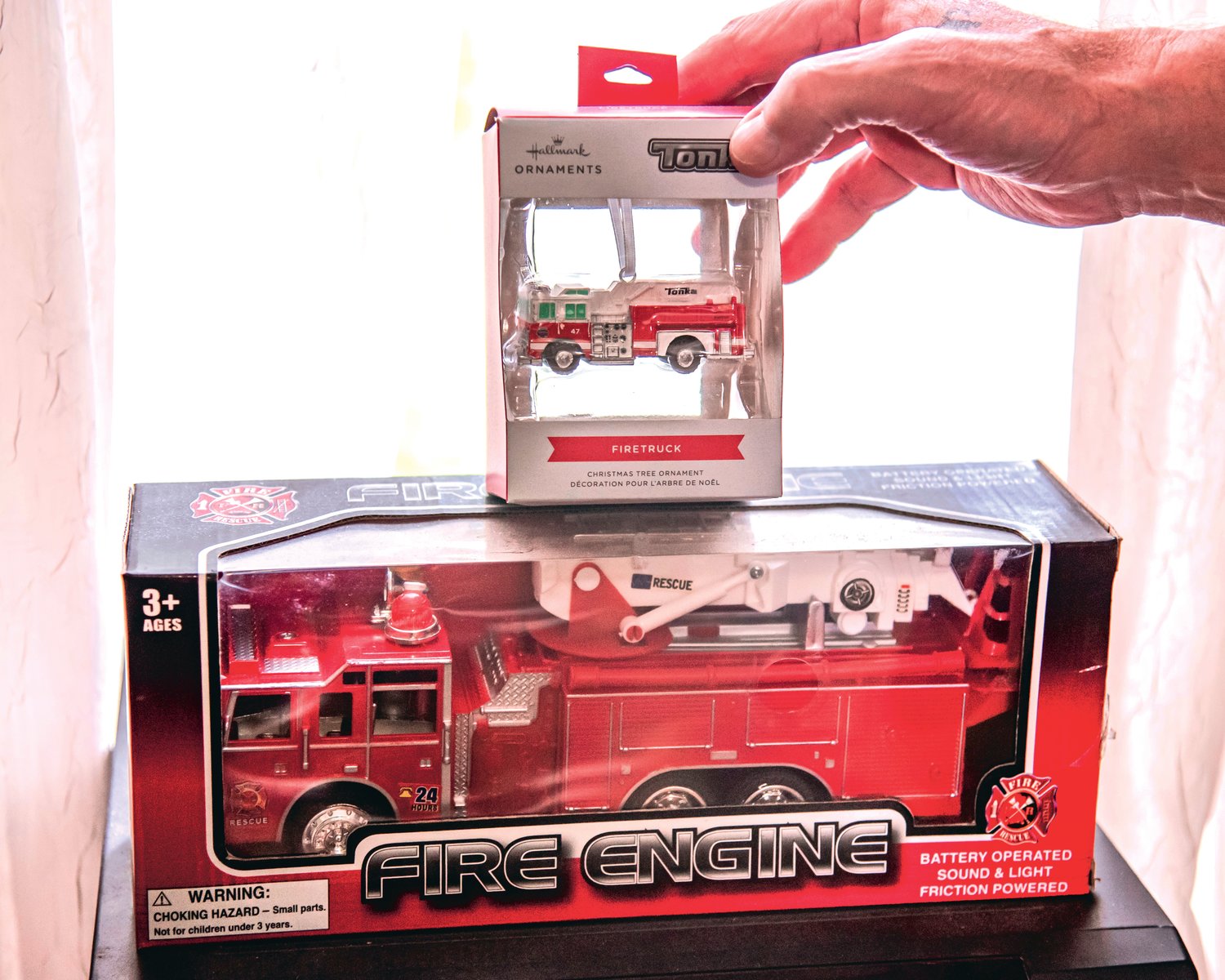 Charles Tippett Jr. talks about a firetruck ornament his caregiver bought for him that he keeps displayed in his living room in a Hallmark box Saturday in Centralia.