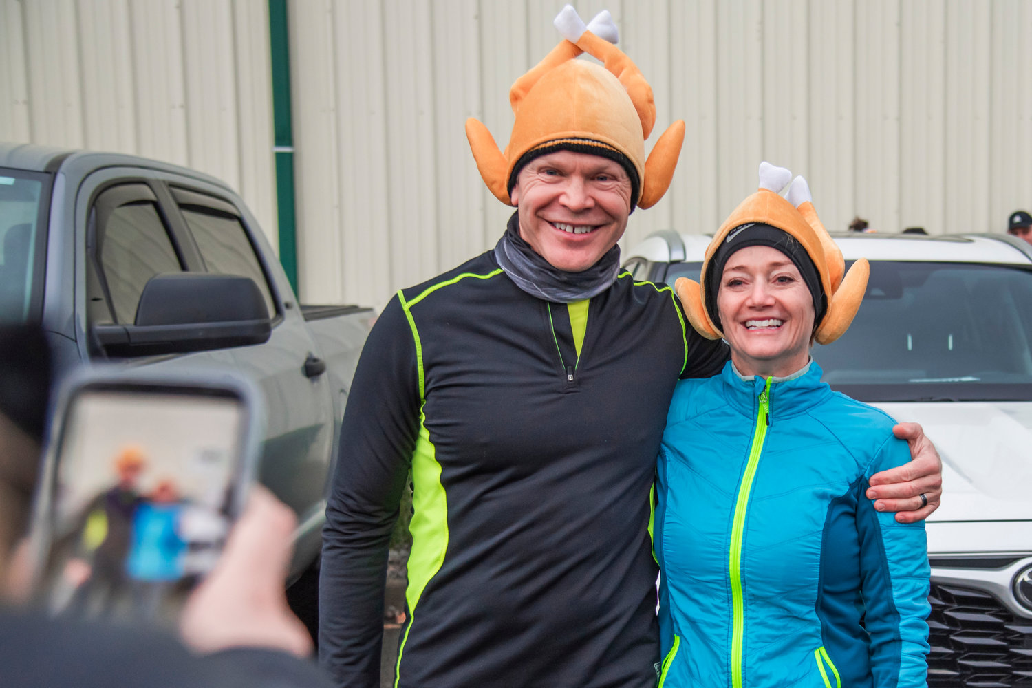 Todd and Denise Gentzler smile and pose for a photo with turkey caps before participating in a Turkey Trot 5k in Chehalis on Thanksgiving Day.