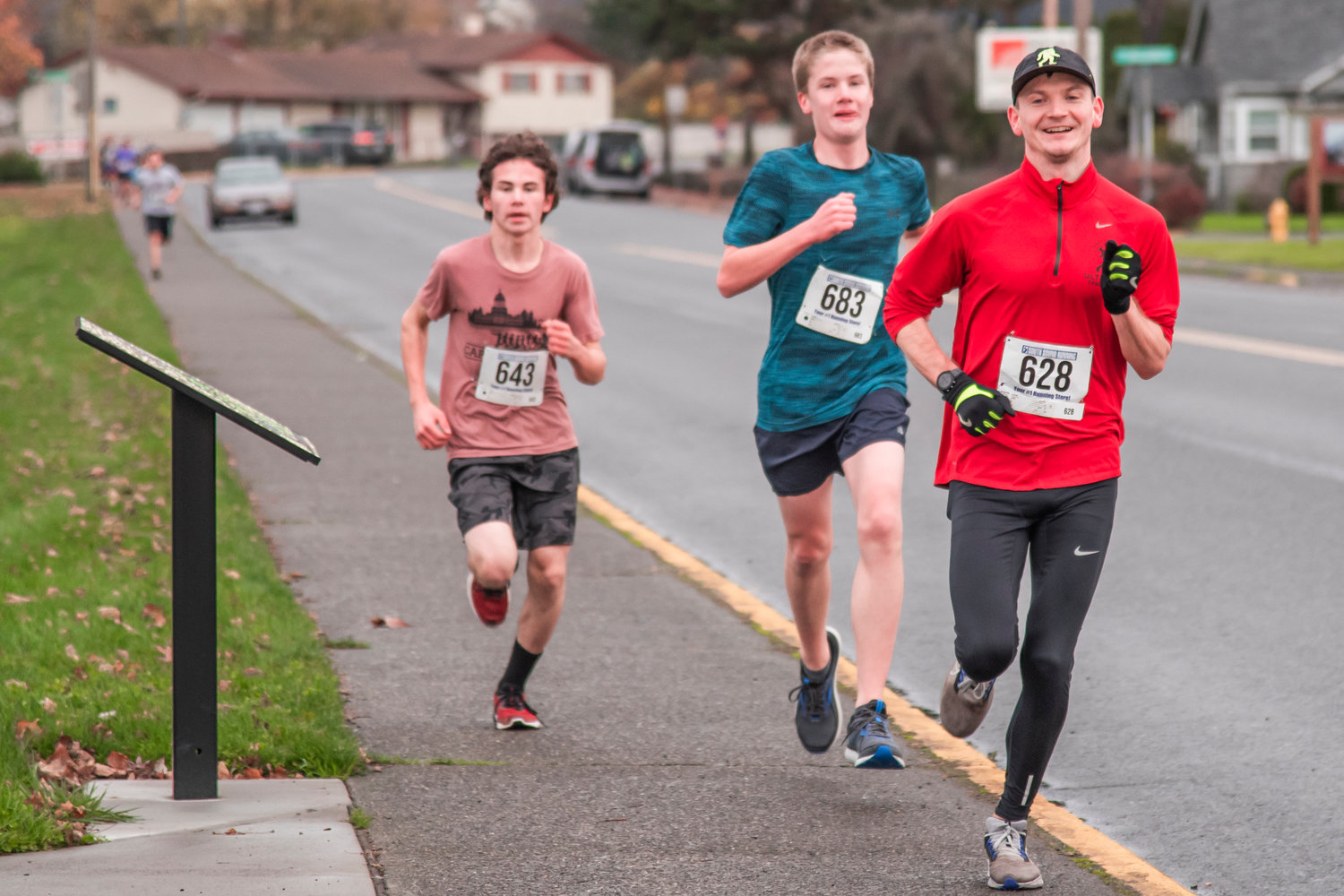 Runners smile as they run around Recreation Park during a Turkey Trot 5K on Thanksgiving Day in Chehalis.