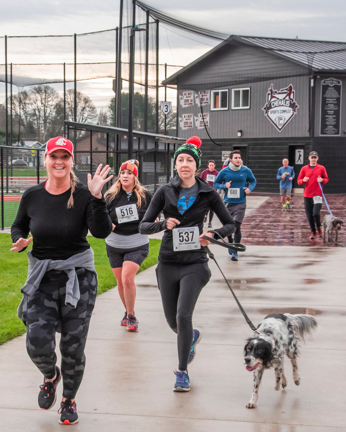 Runners smile and wave as they run through the Chehalis Sports Complex during a Turkey Trot 5K Thursday morning.