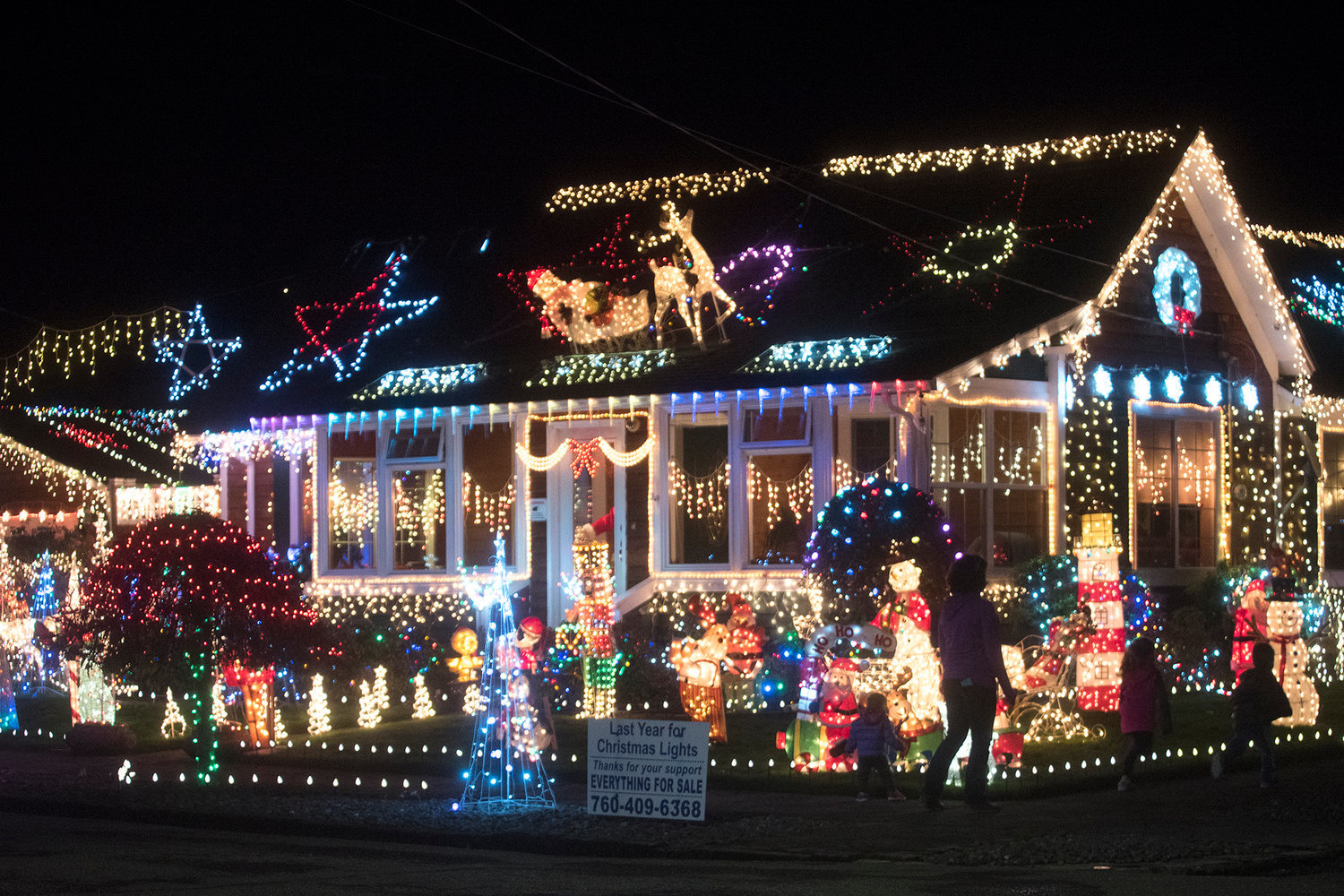 A family walks past lighted house on Cedar Street in Centralia in this 2016 Chronicle file photo.
