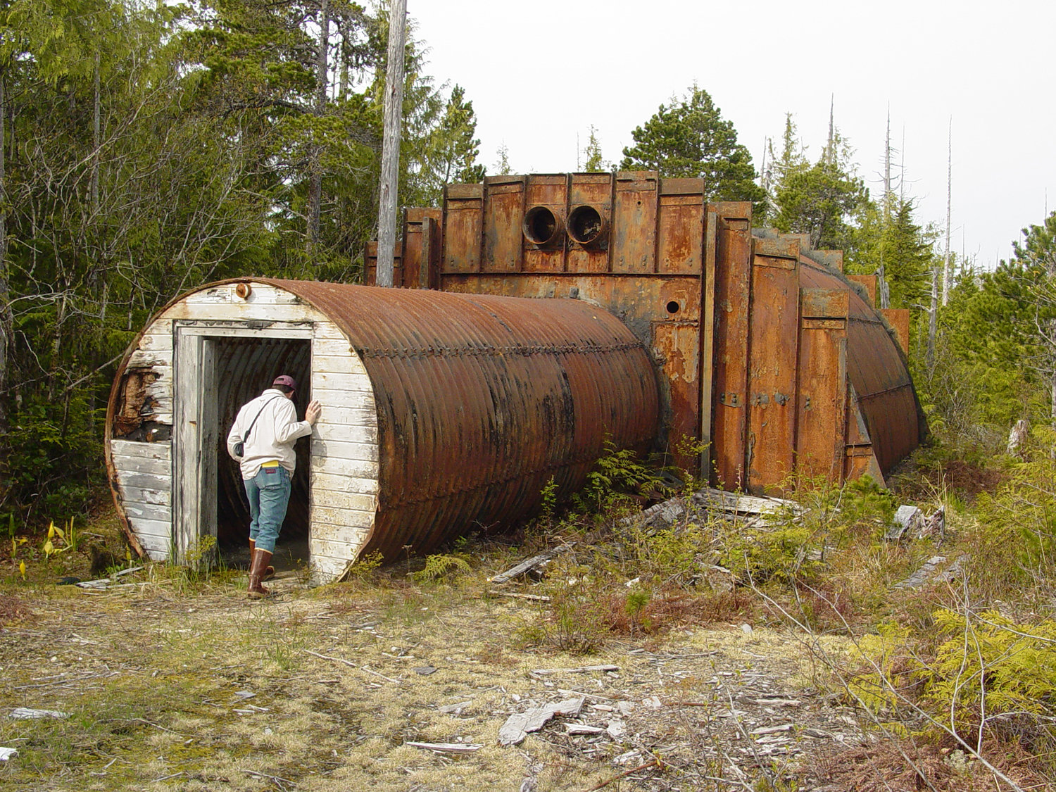 A community member peers into an abandoned military structure on Annette Island. Starting in 1940, the military and other federal agencies used the island for various purposes, leaving structures and debris behind as the land changed hands. The U.S. Army Corps of Engineers – Alaska District administers the contract under which the Metlakatla Indian Community performs cleanup efforts for the Native American Lands Environmental Mitigation Program. (U.S. Army Corps of Engineers – Alaska District photo/TNS)