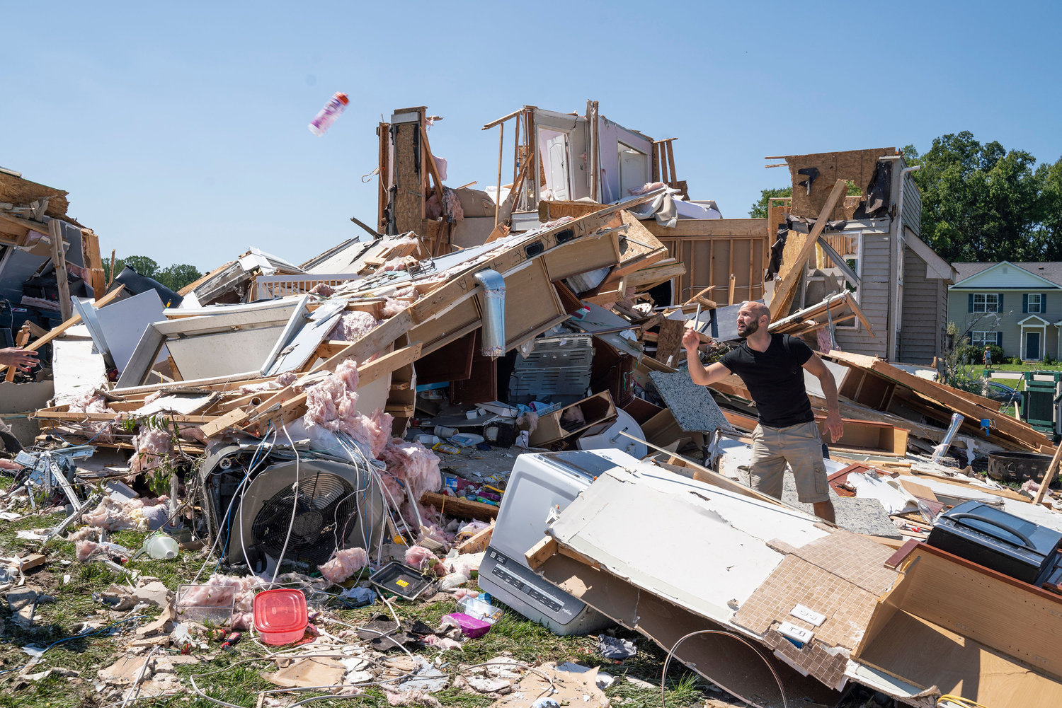 Sam Catrambone clears debris away from a friend's home, damaged by a tornado in Mullica Hill, New Jersey on Sept. 2, 2021 after record-breaking rainfall brought by the remnants of Hurricane Ida swept through the area. (Branden Eastwood/AFP/Getty Images/TNS)