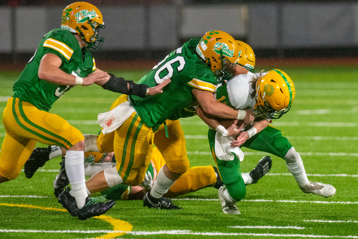 Tumwater’s Bennet Ferris (56) and Austin Terry tackle Lynden quarterback Kaeden Hermanutz during the 2A state title game on Dec. 4.