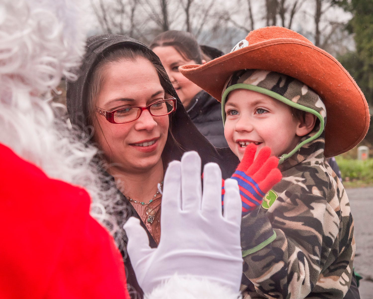 Mark Burleson, 4, smiles as he receives a high-five from Santa outside the Adna Grocery Store on Saturday.