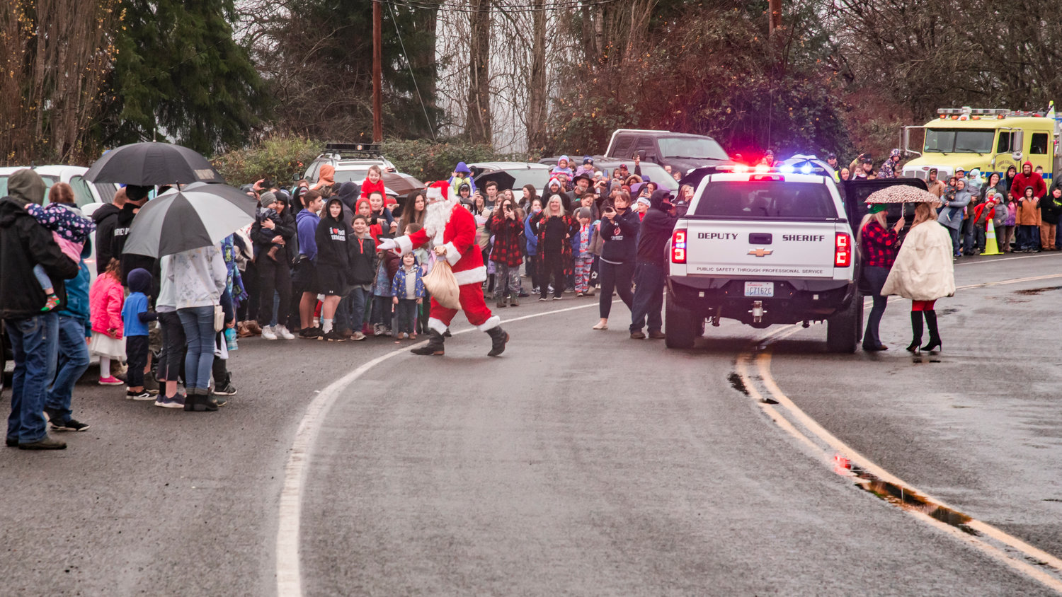 Santa arrives with a Sheriff Deputy escort to the Adna Grocery Store on Saturday.