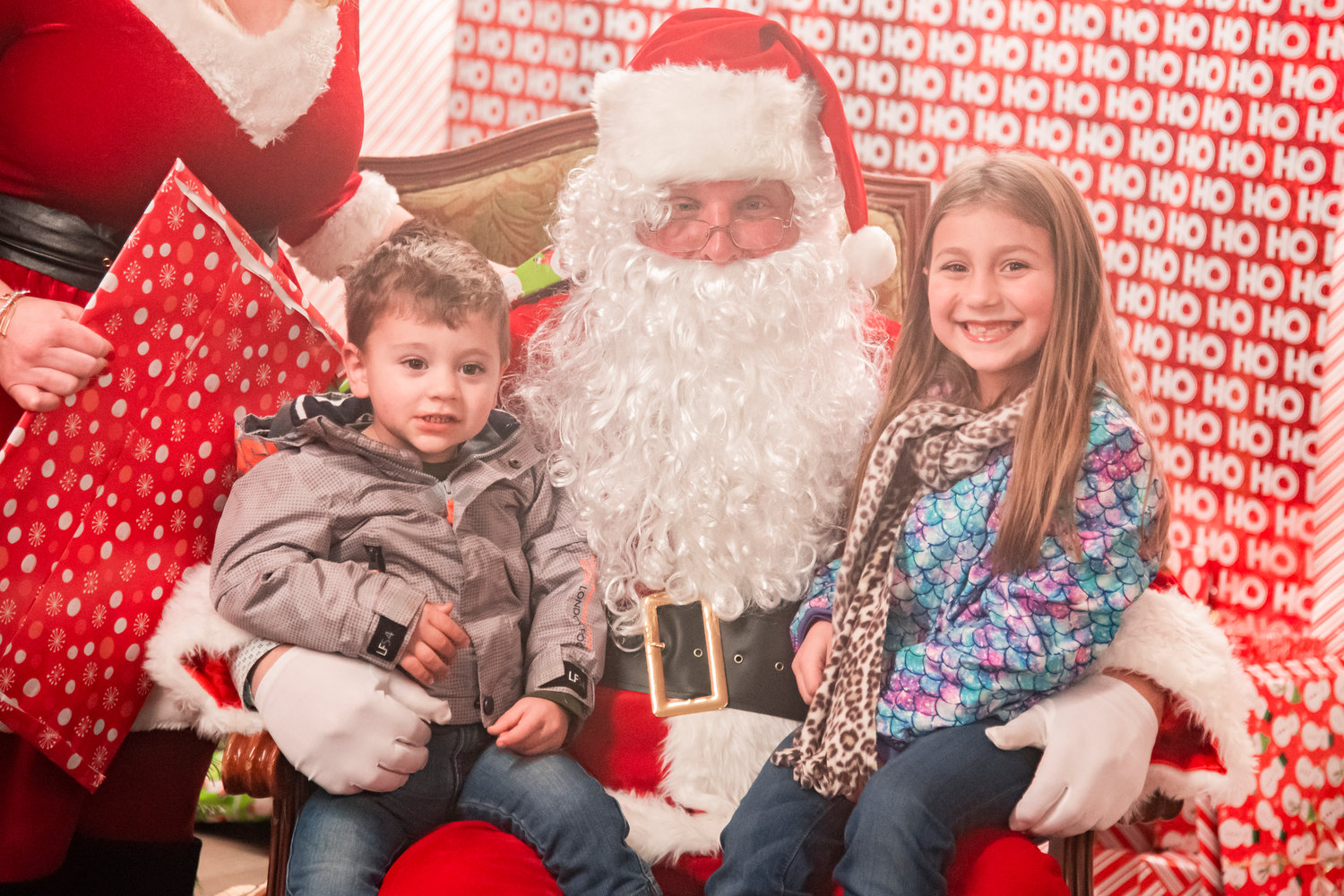 Carver, 2, and Piper, 6, smile and pose for a photo with Santa at the Adna Grocery Store on Saturday.