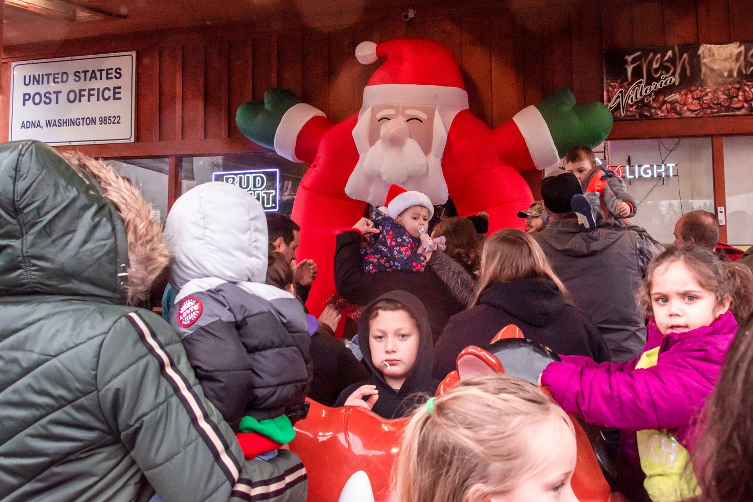 Crowds of parents and kids wait outside the Adna Grocery Store to meet Santa.