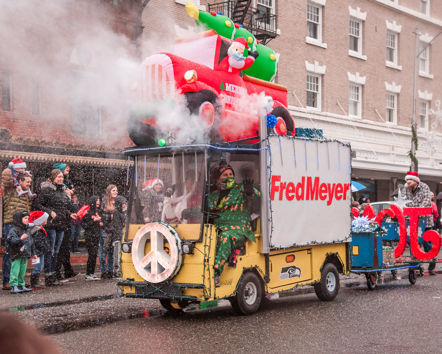 A snow machine rides through downtown Chehalis on a Fred Meyer float during the Santa Parade in downtown Chehalis on Saturday. “Peace on Earth,” was the theme for the parade.