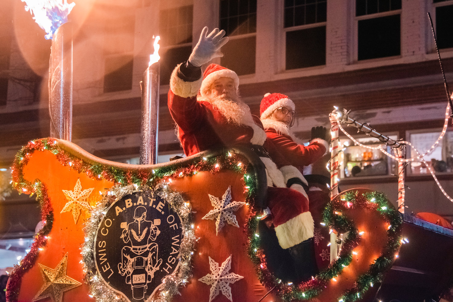 Santa and Mrs. Claus wave to parade-goers from the Lewis County A.B.A.T.E of Washington float during the Lighted Tractor Parade in Centralia Saturday night.