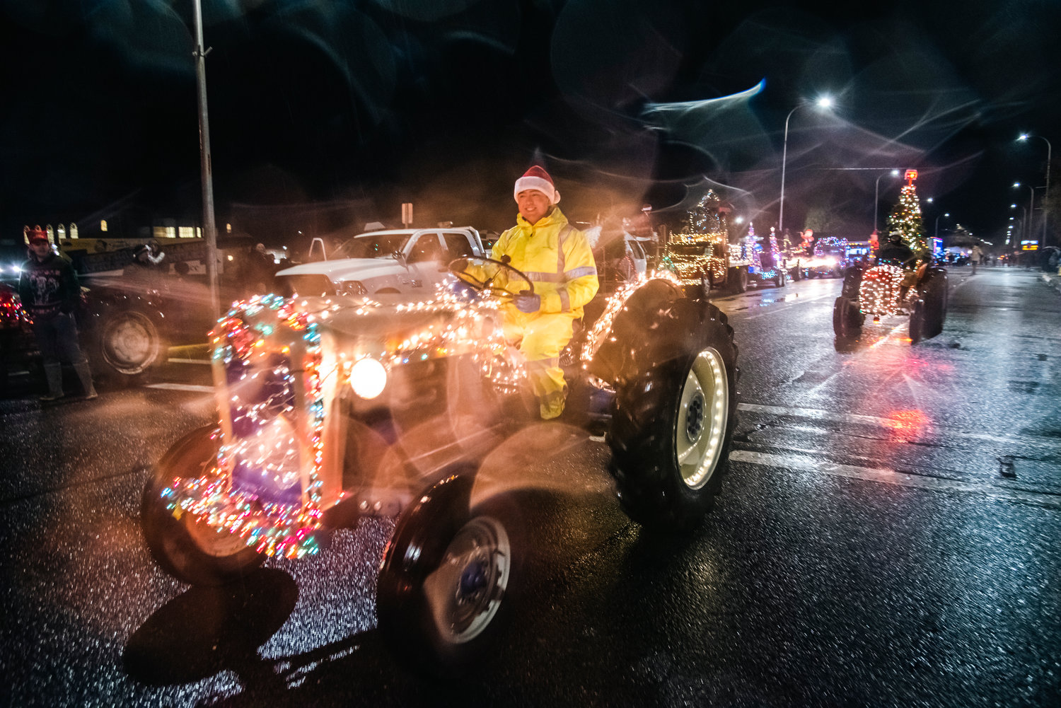 Tractors illuminated with Christmas lights drive down North Pearl Street in Centralia Saturday night during the Lighted Tractor Parade.