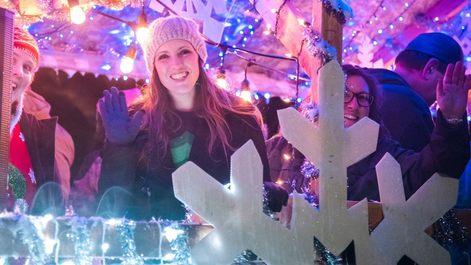 Community members smile and wave while surrounded by lights on a float Saturday night during the Lighted Tractor Parade in Centralia.
