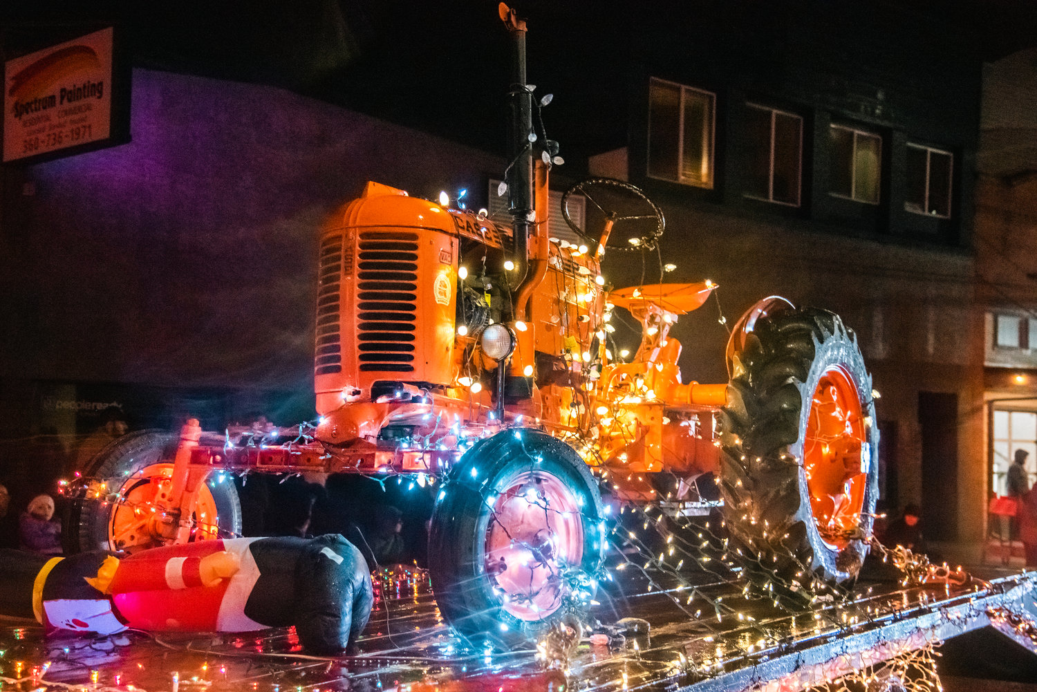 A tractor is paraded on a trailer decorated with Christmas lights in Centralia Saturday night during the Lighted Tractor Parade.