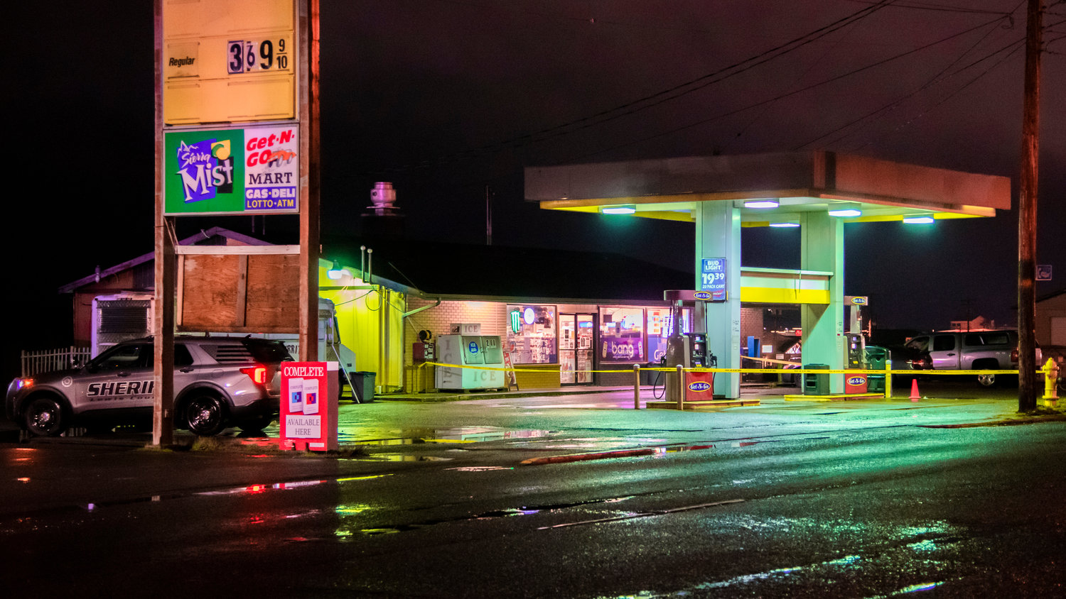 A Lewis County Sheriff is seen parked next to the Get-N-Go Mart in Chehalis where police tape surrounds pumps near the entrance of the building Monday night.