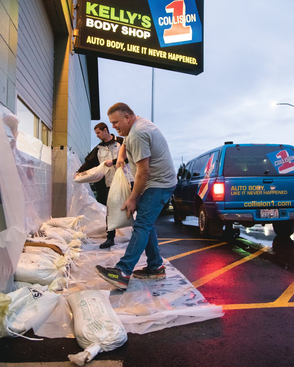 Evan Nelson and Craig Carlson stack sandbags outside Kelly’s Body Shop in Centralia Friday morning.