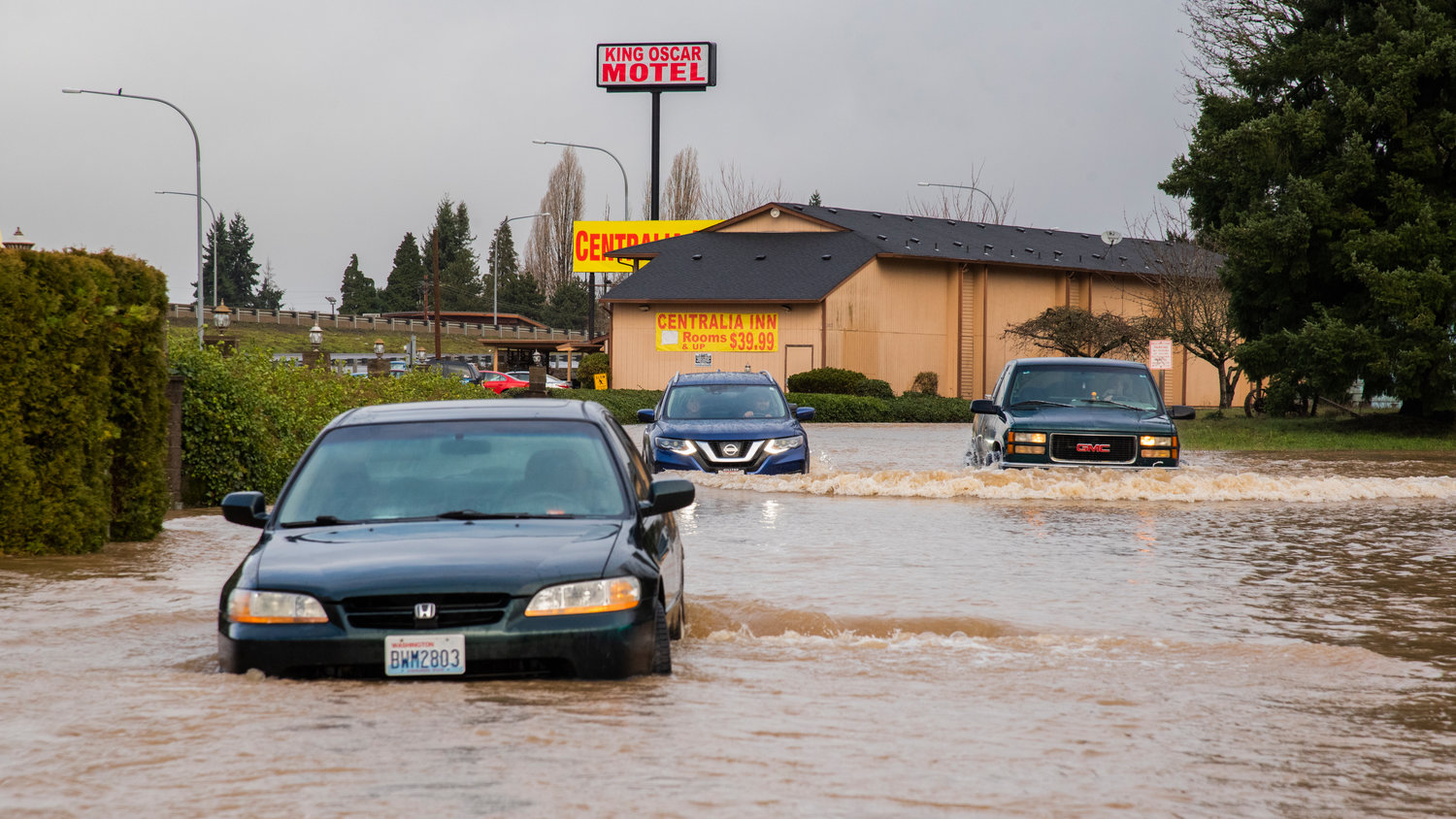 Drivers make their way through floodwaters along Eckerson Road in Centralia Friday morning as some cars remain stranded.