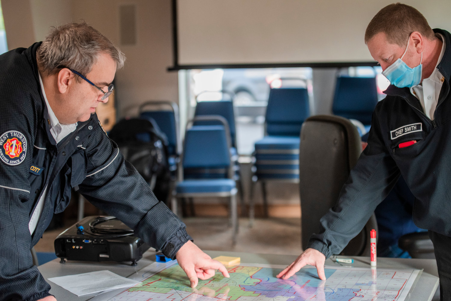 Chiefs Robert Scott and Rob Smith with West Thurston Regional Fire Authority point out road closures and inundated areas on a map of the Grand Mound and Rochester area on Saturday.